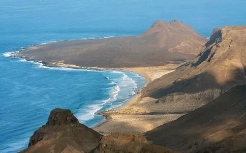 Küstenlandschaft mit Bergen und Strand am Meer.