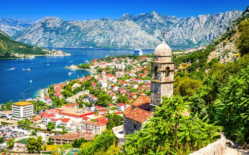 Mittelalterlicher Glockenturm mit Blick auf Küstenstadt Kotor, umgeben von Bergen und Meer.