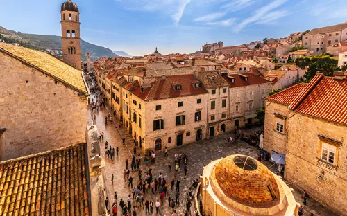 Historische Altstadt mit Menschen, weitem Himmel und alten Gebäuden.
