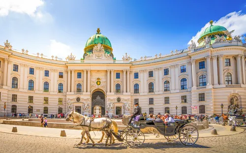 Die Hofburg in Wien mit einer Pferdekutsche auf dem Heldenplatz.