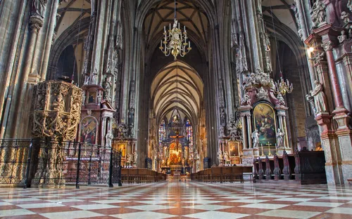 Innenansicht einer gotischen Kathedrale mit hohen Gewölben und kunstvollen Verzierungen.