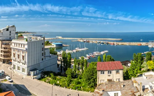 Panoramablick über eine Küstenstadt mit Hafen und blühendem Himmel.