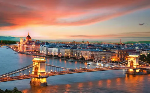 Panoramablick auf Budapest mit Kettenbrücke und Parlamentsgebäude bei Sonnenuntergang.