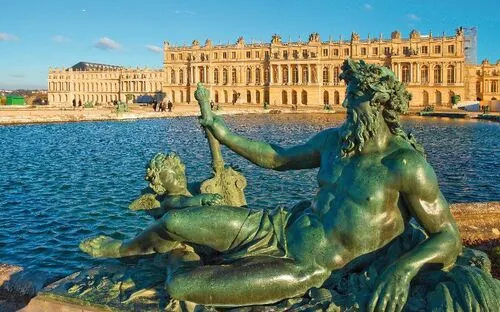 Brunnenfigur vor dem Schloss Versailles bei sonnigem Wetter.