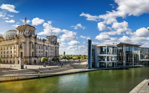 Panorama des Berliner Regierungsviertels mit Reichstag und Spree bei Sonnenschein.