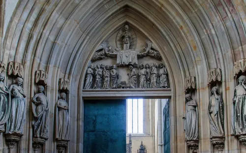 Steinerne Kirchentür mit gotischen Skulpturen und Reliefs.