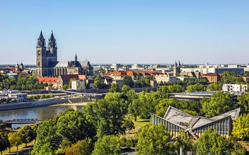 Stadtpanorama mit historischer Kathedrale und Fluss im Vordergrund.