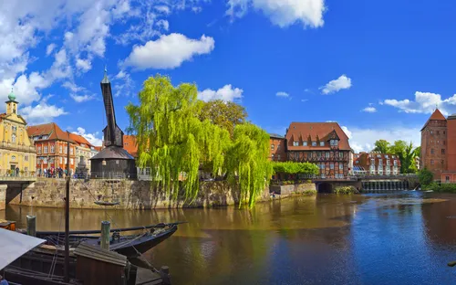 Panoramablick auf historische Architektur und Fluss in Lüneburg bei sonnigem Wetter.