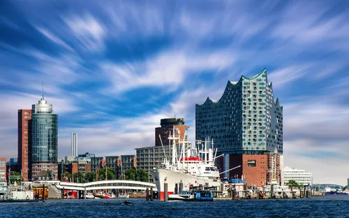 Hamburger Hafen mit der Elbphilharmonie und einem blauen Himmel.