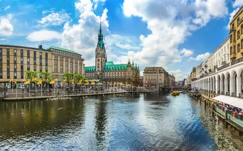 Blick auf das Hamburger Rathaus und den Alsterfleet bei sonnigem Wetter.