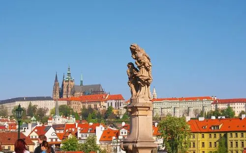 Blick von der Karlsbrücke in Prag auf Burg und Altstadt im Sonnenschein.