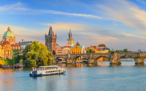 Panoramablick auf Prag mit Karlsbrücke und Moldau im Vordergrund.