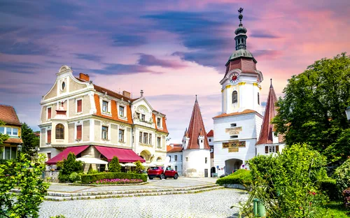 Malerische Altstadt mit Kirche und historischem Gebäude bei Sonnenuntergang.