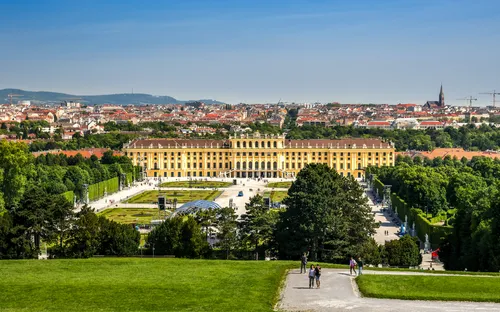 Schloss Schönbrunn in Wien mit Gärten im Vordergrund.